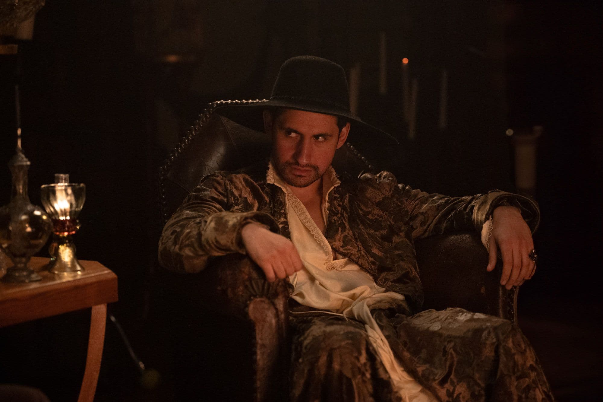 Amir El-Masry sits slouched in a chair in "100 Nights of Hero."