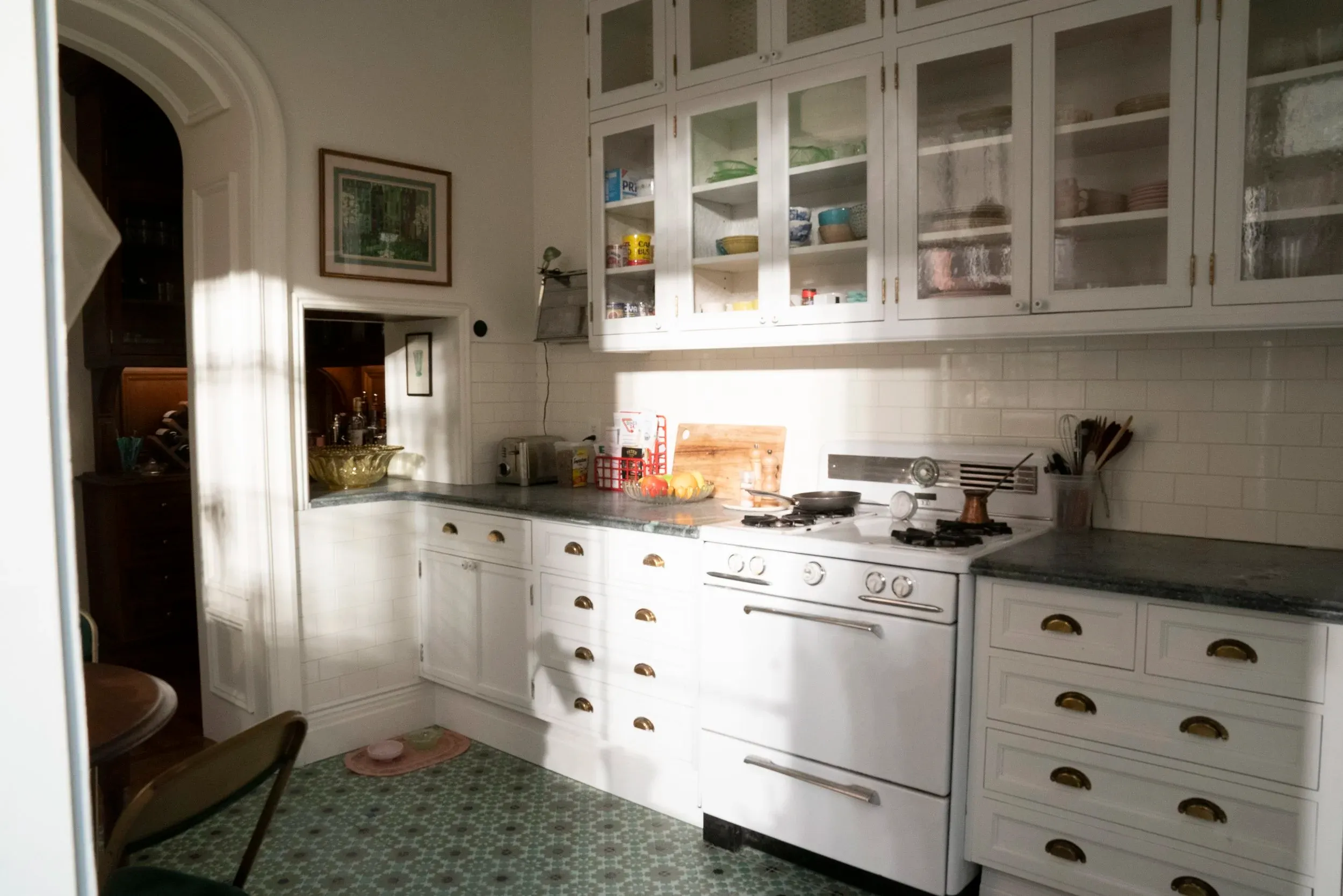 A photo of a kitchen with all white cabinetry, from the HBO series "And Just Like That"
