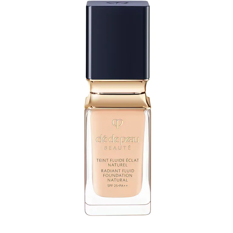 A bottle of Cle de Peau Beaute Radiant Fluid Foundation in a light beige shade, against a white background.