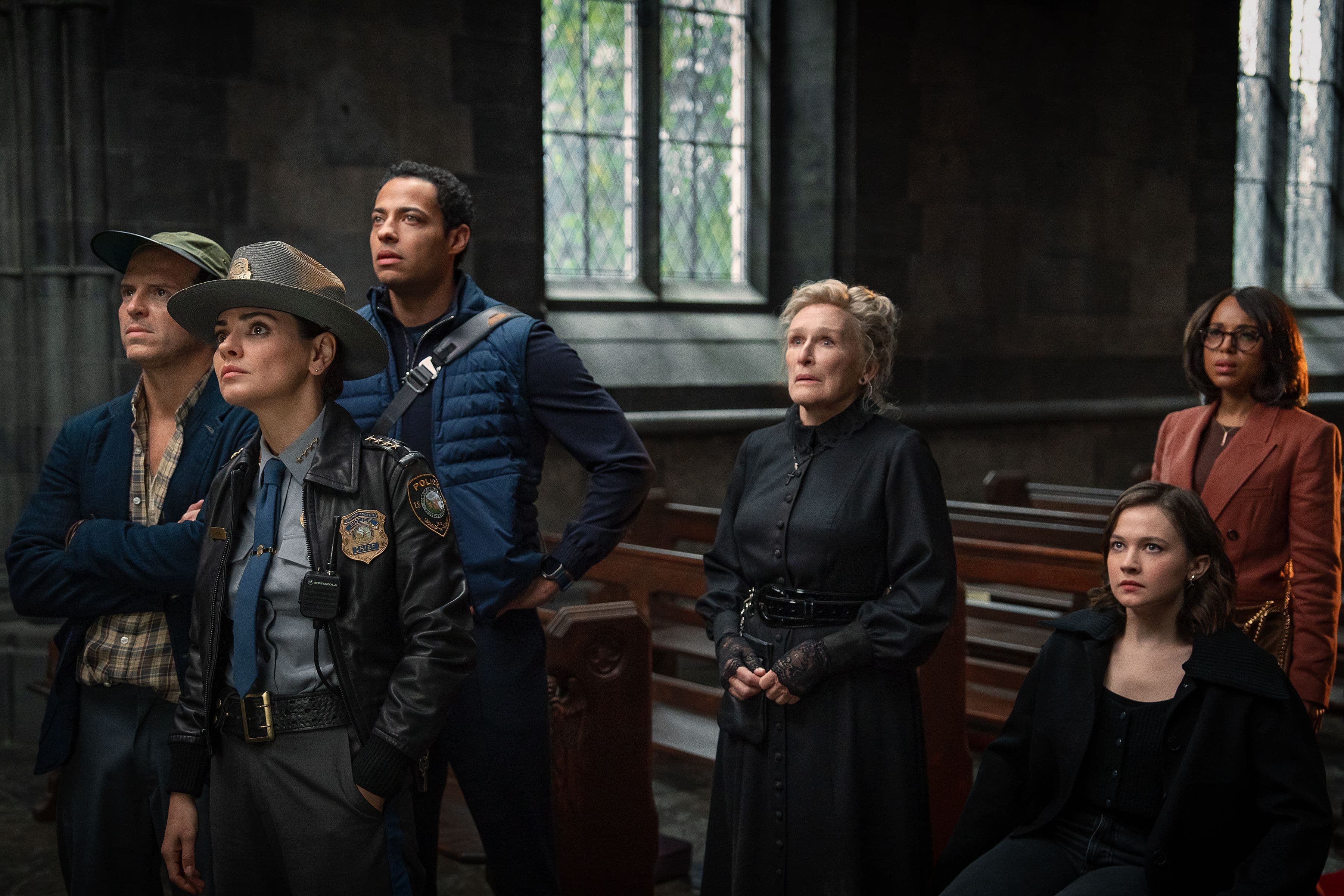 Actor Glenn Close stands beside police officers in a church.
