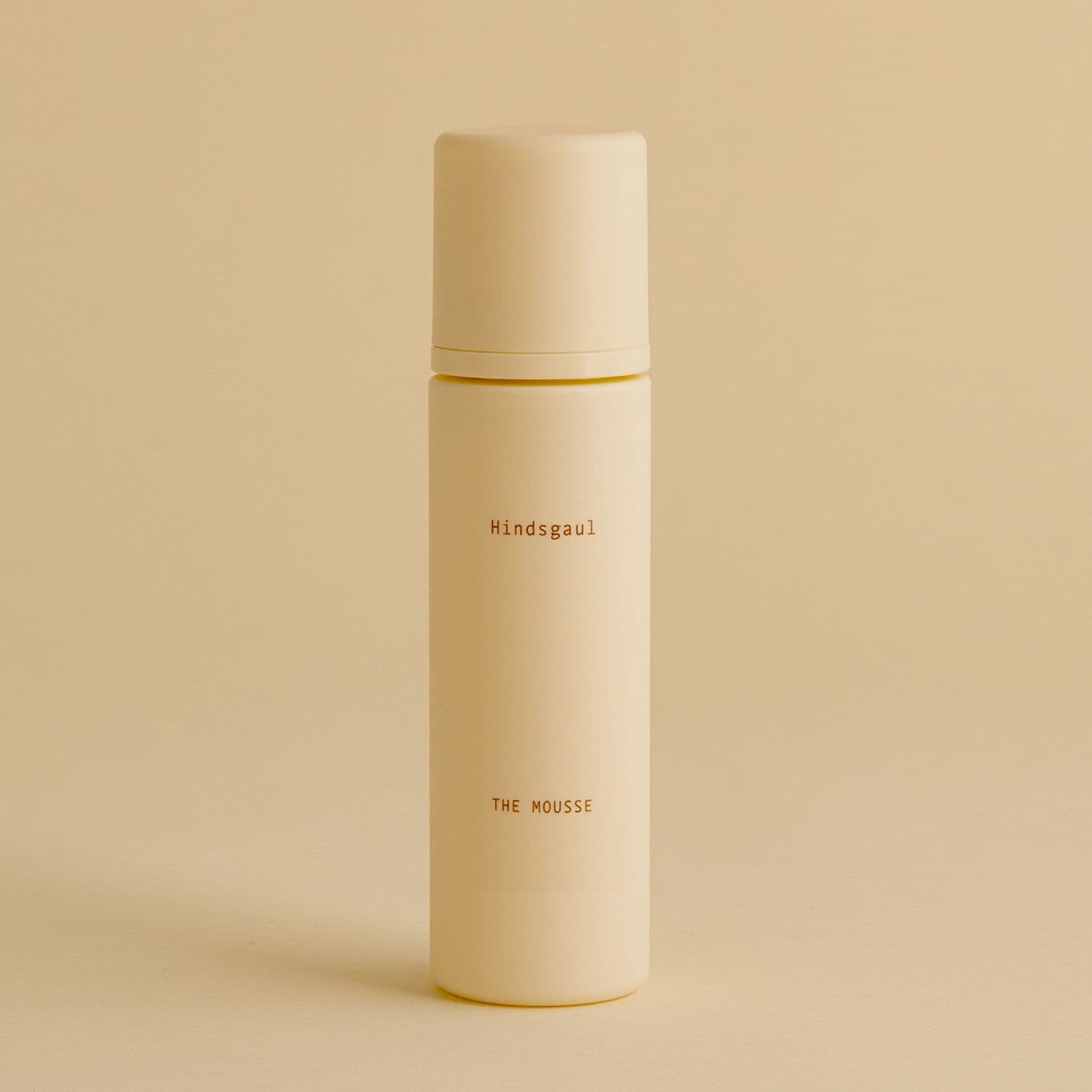 A tube of the Hindsgaul Hair Mousse against a pale yellow background