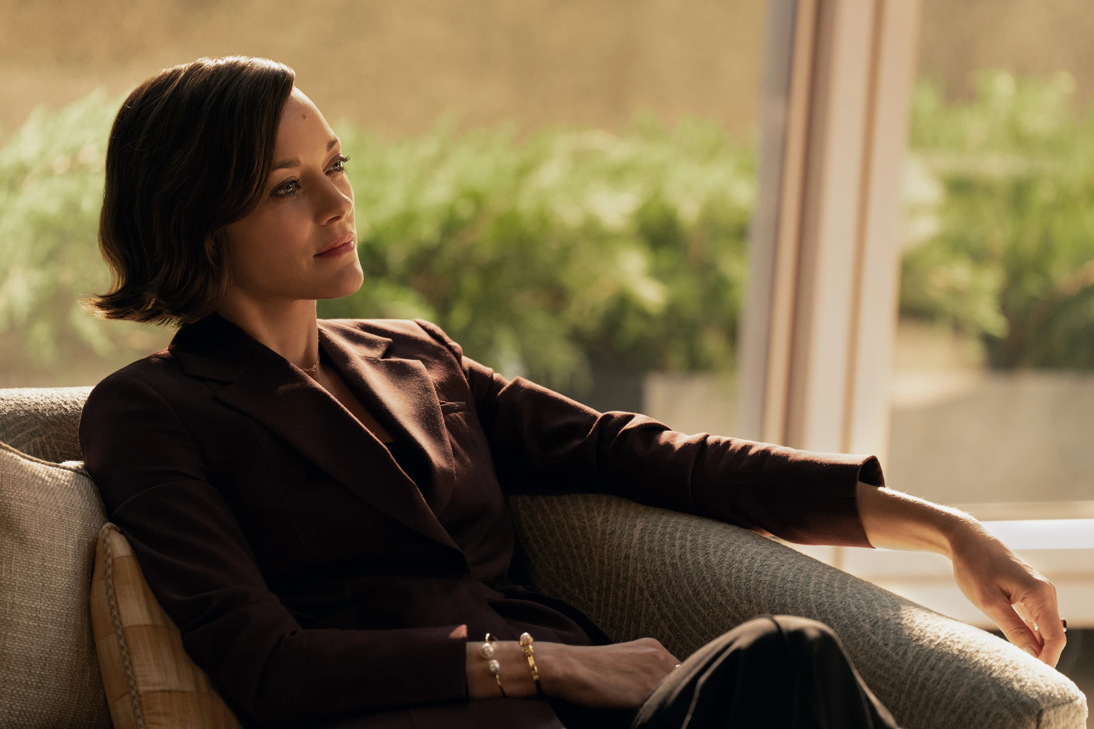 Marion Cotillard sits on a chair in a still from The Morning Show.