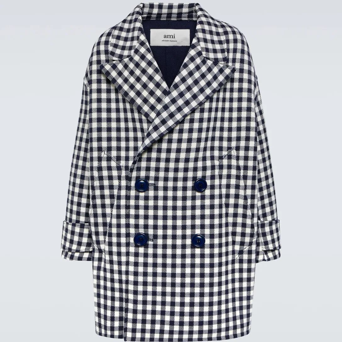 An oversized black-and-white houndstooth coat from Ami Paris against a gray background